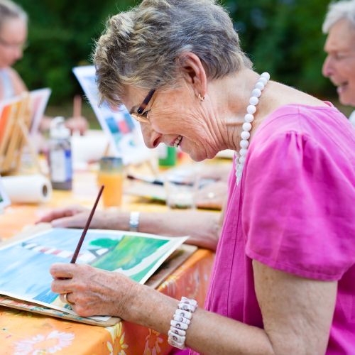 Elderly woman painting a picture